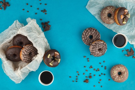 Cooking, baking and food concept - close up of glazed donuts on a blue background. Still life.