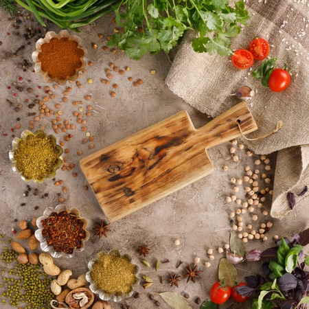 Fresh greens and tomatoes spices cereals and nuts organic healthy snacks on a textural background. Concept of healthy food. Frame under the text.の写真素材
