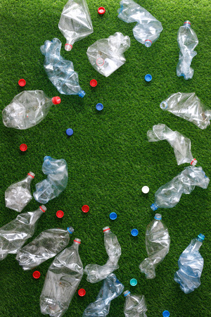 The concept of recycling plastic and environmental protection. Pet preforms for plastic bottles on the green grass. Artificial turf, plastic.の写真素材
