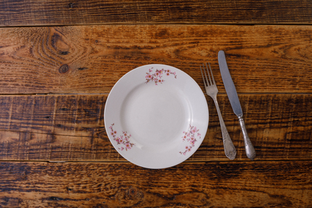 Plate and cutlery on the background of vintage wooden boards. Vintage background and space for text. View from above. Flat lay. Cutlery. Vintage.の写真素材