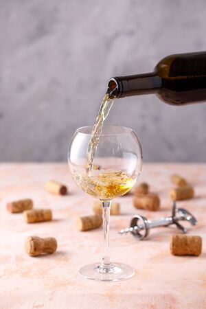 White wine is poured into a glass. The concept of winemaking. Place under your text. Close-up.の写真素材