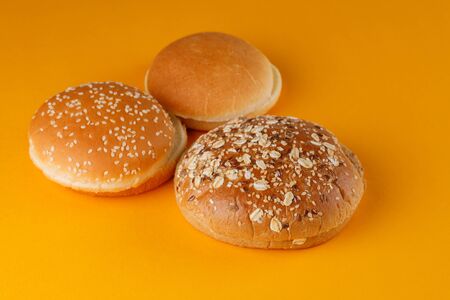 Rye and classic bun empty isolated. American food classic rye round burger bread isolated on orange...