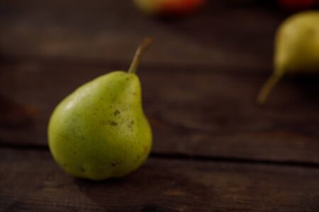 Fresh green pears against an old textural wooden surface, close up. Autumn harvest of pears.の写真素材