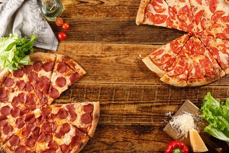 Pizza Pepperoni and Margarita on a wooden table. Still life with ingredients. Top view. Copy space.の写真素材
