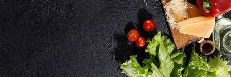 Ingredients for pizza. Tomatoes, olive oil, greens and parmesan on a wooden background. Banner. Copy space.の写真素材
