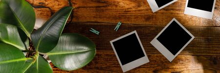 Top view of blank photographs next to a camera on a wooden table. The concept of pleasant memories.の写真素材