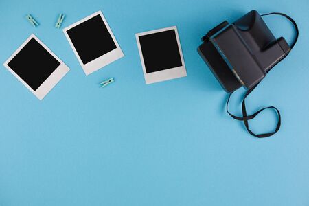 Instant photo frames and camera on a blue background. Concept of preservation of memories. Flat lay....