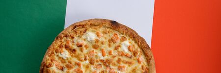 Pizza with salmon and cheese on the background the flag colors of Italy. Close-up. The concept of delicious food. View from above. Copy space.の写真素材