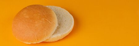 Burger bun empty isolated. American food classic round burger bread isolated on a orange background....