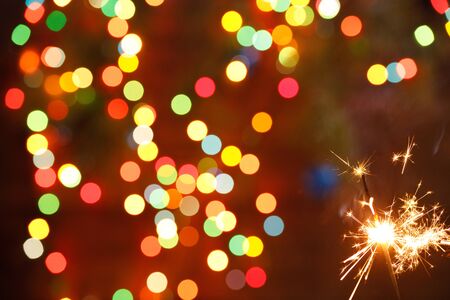 beautiful sparklers on the background of a garland. beautiful holiday card for the New Year. Happy.の写真素材
