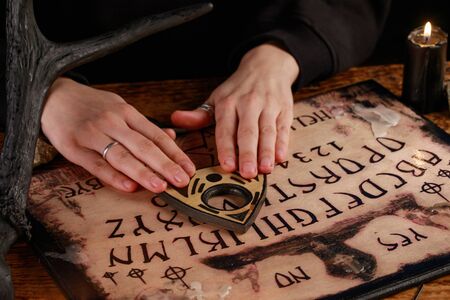 Hands on the devil's board. Session of calling spirits. Occult sciences, the atmosphere of black...