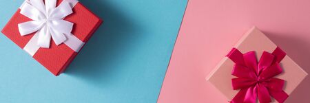 Valentine's Day celebration concept. A nice gift for your loved one. Boxes with bows on delicate blue and pink backgrounds. Copy space. Flat lay. Close-up.の写真素材