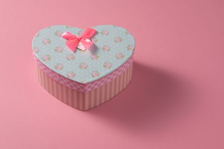 Valentine's Day celebration concept. A nice gift from a loved one. Box with a bow on a delicate pink background. Copy space. Flat lay.の写真素材