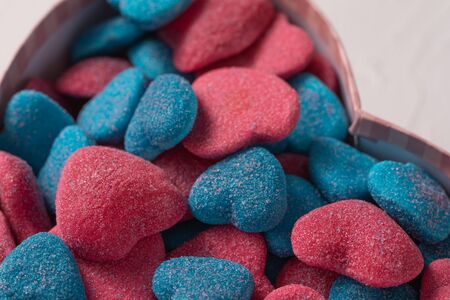 Sweet gift in a box in the form of a heart on a textural background. Marmalade in sugar blue and rose in the form of hearts Valentine's day holiday concept.の写真素材