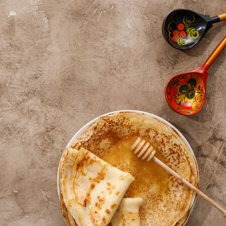 Delicious homemade pancakes with honey on a textural background. Top view, close-up. Traditional...