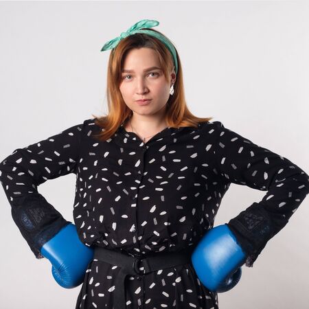 Girl power concept. Confident young woman isolated on gray wall background. Feminine and independent...
