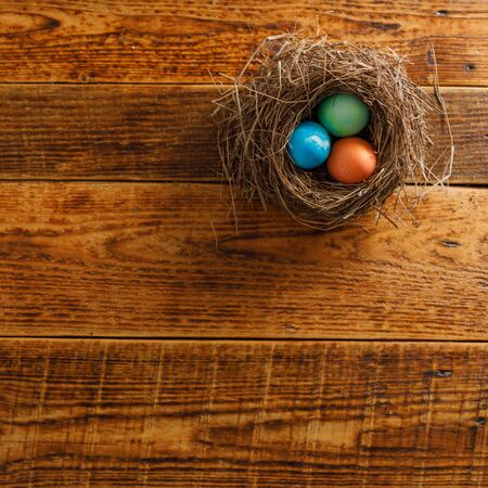Still life of easter eggs in a bird's nest on a wooden background. Rustic. Easter celebration...