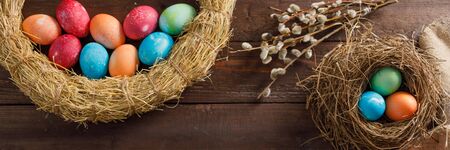 Still life of easter eggs in a bird's nest on a wooden background. Rustic. Easter celebration concept. Copy space. Flat lay. Banner.の写真素材