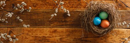 Still life of easter eggs in a bird's nest on a wooden background. Rustic. Easter celebration concept. Copy space. Flat layの写真素材