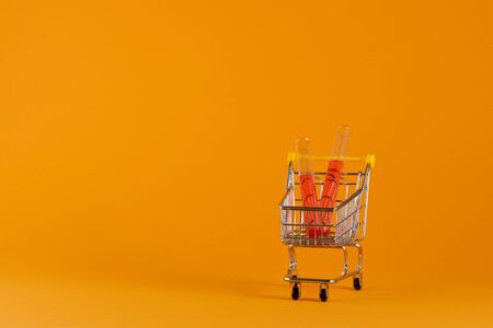 Coronavirus concept. Vaccine. Vaccine in a shopping cart on a yellow background. Covid Virus 2019.の写真素材