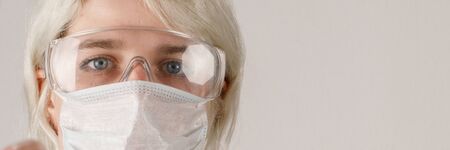 A girl in a protective suit and mask and glasses to protect health from viral, epidemic and...
