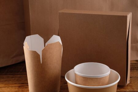 Street fast food paper cups, plates and containers. Eco-friendly food packaging on wooden...
