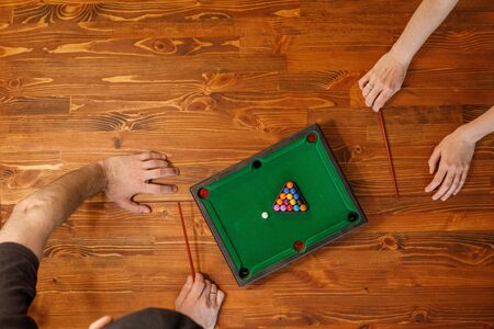Young people play table billiards. Friendship and fun concept. Among friends and they are in a good mood. Top view.の写真素材