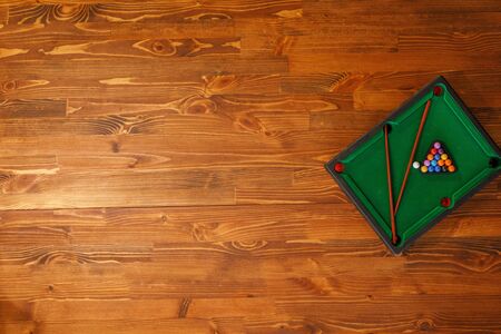 Mini billiard table with cue and balls. Mini snooker billiard game. Green billiard table as Leisure...