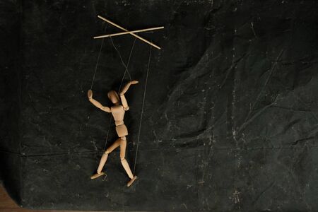 Puppet in the hands of puppeteer walks on isolated, background. Object on a texture background.の写真素材