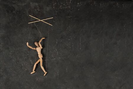 Puppet in the hands of puppeteer walks on isolated, background. Object on a texture background.の写真素材