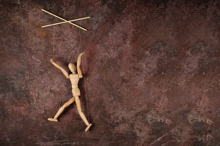 Puppet in the hands of puppeteer walks on isolated, background. Object on a texture background.の写真素材