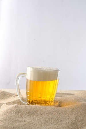 Cool drinks on the beach sand. Cold foamy beer.の写真素材