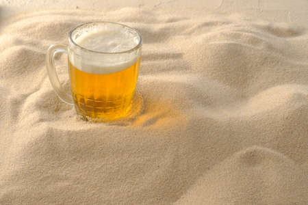 Cool drinks on the beach sand. Cold foamy beer.の写真素材