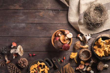 Autumn harvest of mushrooms on vintage rustic wooden background. Rustic kitchen table. Flat lay top, top view. Layout with free text space.の写真素材