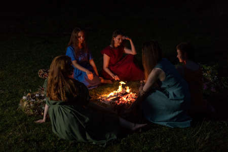 Lovely girls by the fire at night. Ancient pagan origin celebration concept. Night of Ivan Kupala.の写真素材