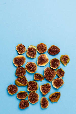 slices of dried figs on a blue background. dried fruits. eco. top view. banner.
