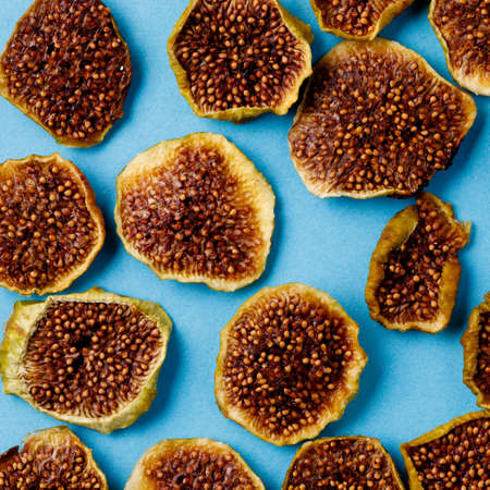 slices of dried figs on a blue background. dried fruits. eco. top view. banner.