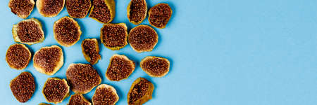 slices of dried figs on a blue background. dried fruits. eco.top view. banner.