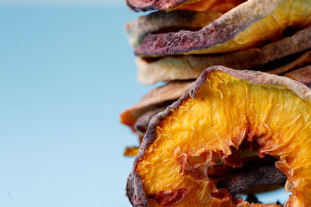 slices of dried peach on a blue background. dried fruits. eco. macro.