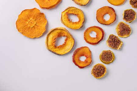 slices of dried persimmon, peach, plum and figs on a white background. dried fruits. eco. delicacy.の写真素材