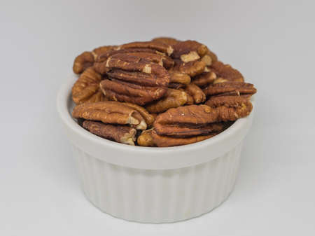 A pile of pecan nuts  in the white cup