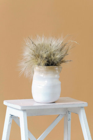 White scandinavian ceramic vase on a beige backgroundの写真素材