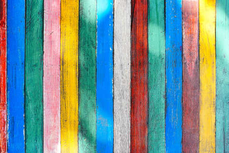 Mulricolored wooden table board surface background or wallpaper. Thin colorful vertical rough boards...