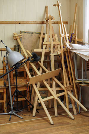 Pile of wooden easels and other art stuff in corner of art school classroom. Art suppliesの写真素材