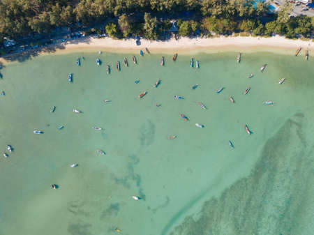 Many wooden traditional fishing boats on the water near the shore. Birds eye view