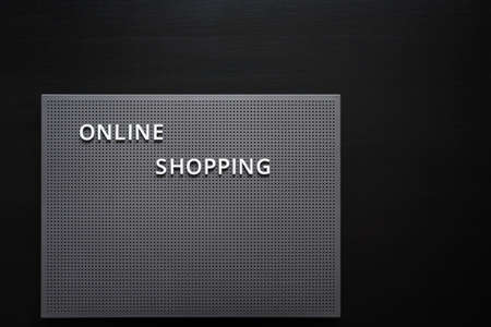 Online shopping phrase on dark grey board on black background Conceptual photography Shopping from...