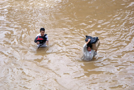 Jakarta resident across the flooding street in Kampung Melayu, Jakarta, Indonesia.のeditorial素材