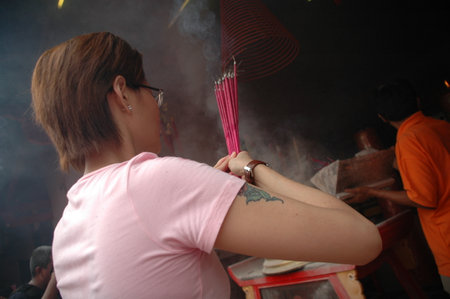 Jakarta, Indonesia - February 14, 2010: People with burner incense in hand pray at Jin De Yuan temple, Jakarta, Indonesiaのeditorial素材