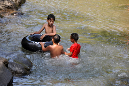 Ciamis, Indonesia - June 30, 2017: Children are swimming in the river using a float, Ciamis, Indonesiaのeditorial素材