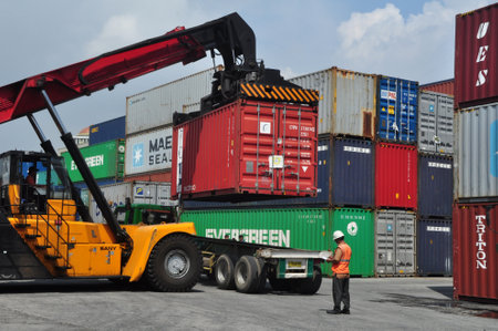 Jakarta, Indonesia - May 6, 2017: Container unloading truck in logistics yard at the port of Tanjung Priok, Jakarta, Indonesia.のeditorial素材